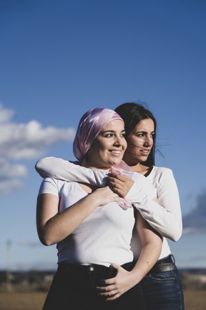 Two young woman with cancer scarf