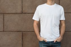 Men in blank t-shirt against building, space for text