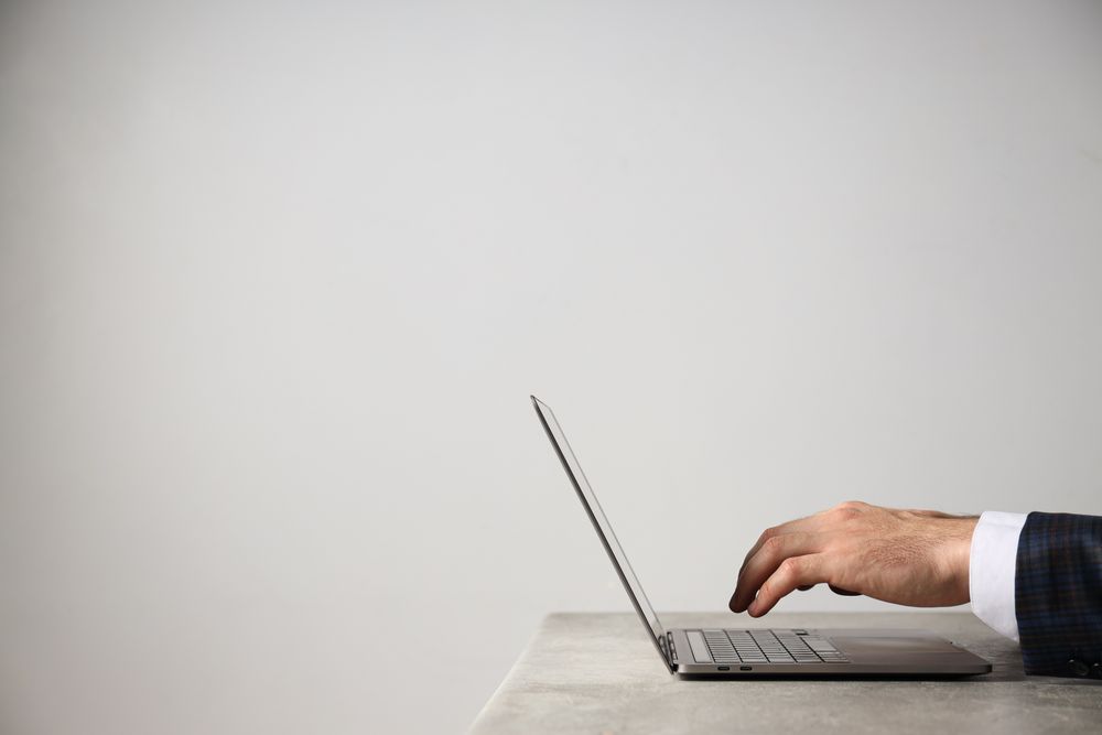 A man in a suit works on a laptop
