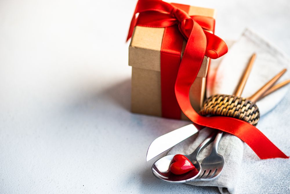St Valentine day table setting with red heart and napkin ring and gift
