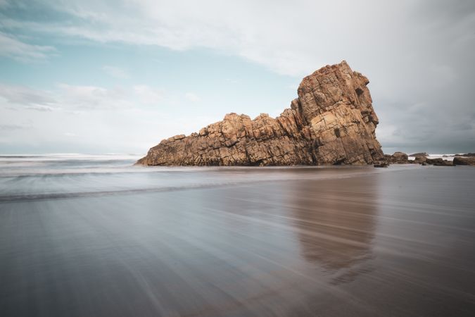 Coastal rock on beach and overcast sky