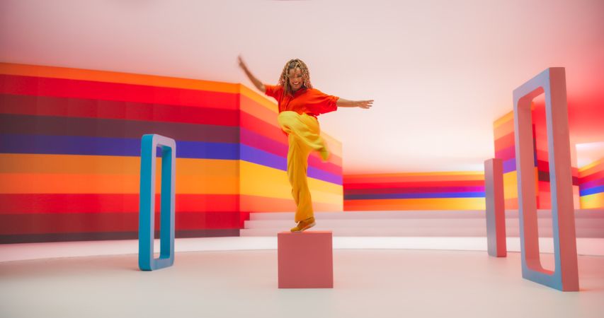 Portrait of Talented Black Female Artist Showcasing Dance Movements in Abstract Colorful Studio Decoration.