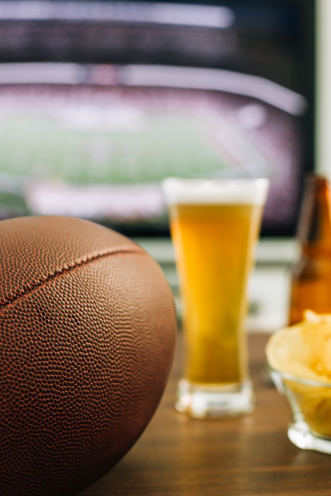 Beer and snacks prepared for watching american football on TV