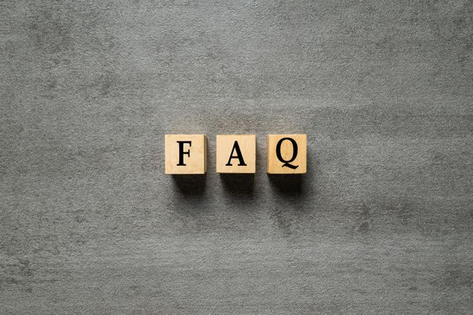 frequently ask question or FAQ letter symbol on wooden cubes isolated on cement background