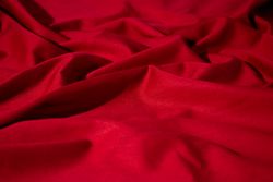 Crumpled wavy Red silky fabric background texture.