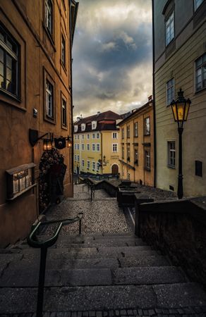 Alley between building under cloudy sky