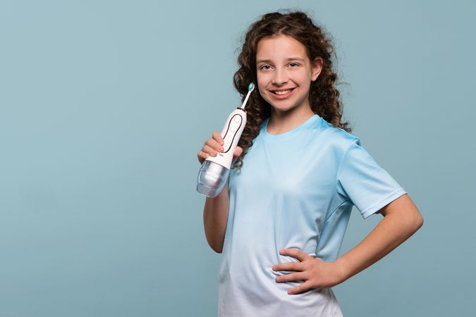 Young girl holding an electric toothbrush