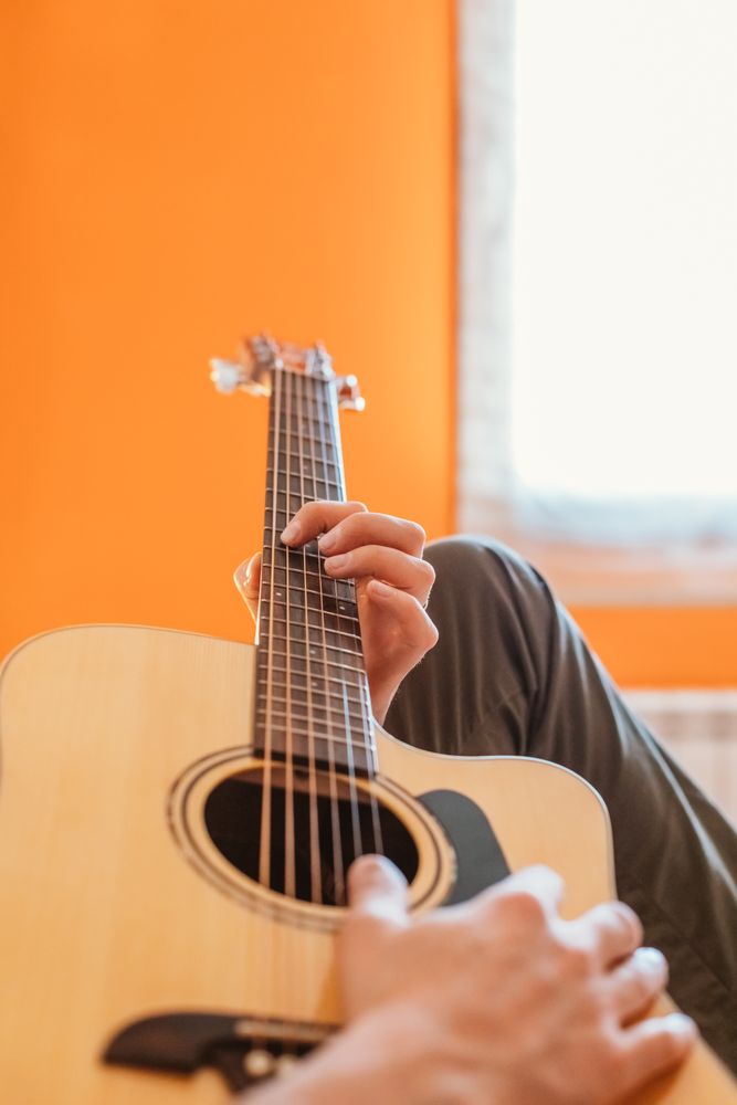 Man playing the guitar on the bed
