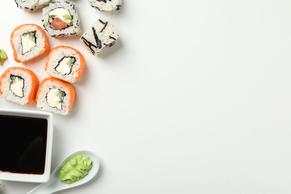 Delicious sushi rolls on plain background, top view. Japanese food