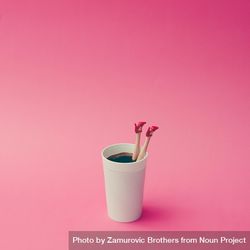 Coffee cup with female doll legs on pink background, with copy space 0LaYr5