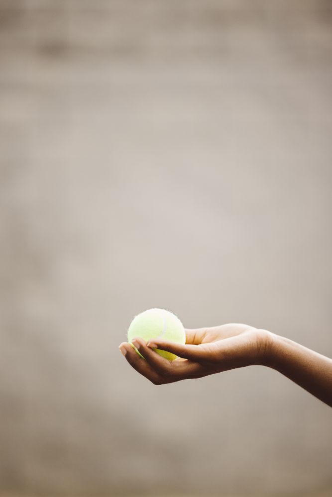 Hand holding a tennis ball