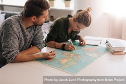 Couple planning trip with world map bYqe96
