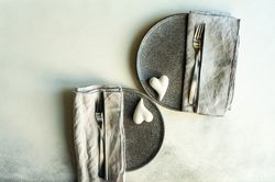 Looking down on grey plates and hearts for romantic dinner