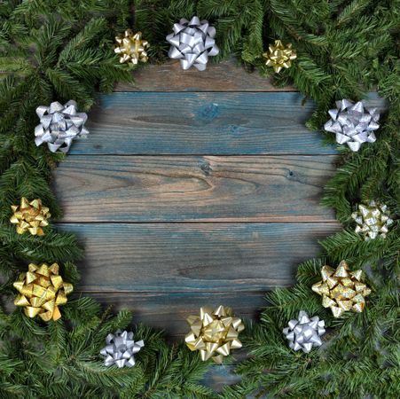 Christmas wreath with bows on blue faded wooden planks