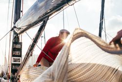 Sailor on yacht arranging the covering