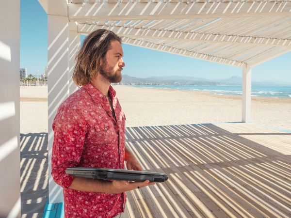 Man using laptop on beach