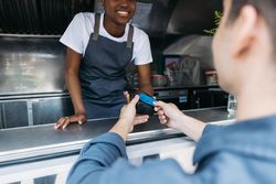 Male paying food truck vendor with tap card