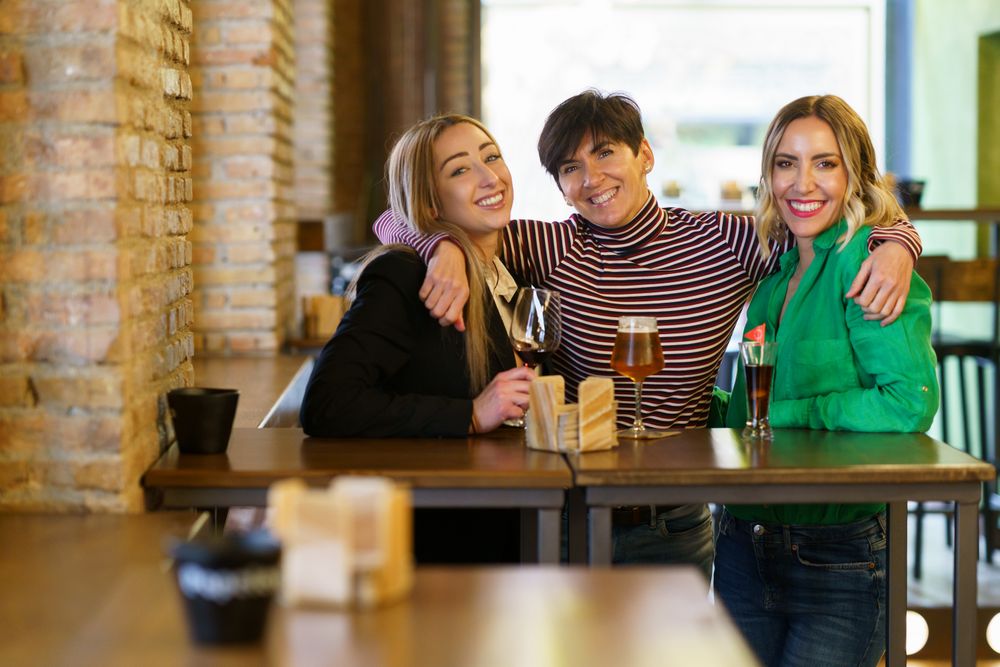 Happy female friends posing together for photograph in bar