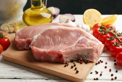 Composition with raw meat for steak and ingredients on wooden background