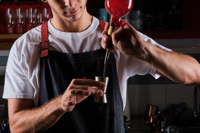 Crop man mixing drink in bar