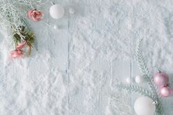Wooden table background with snow and flowers and festive pink decorations