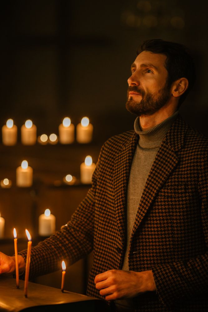 Devout Christian Man Lighting a Candle in Church, Praying and Expressing Devotion to God.