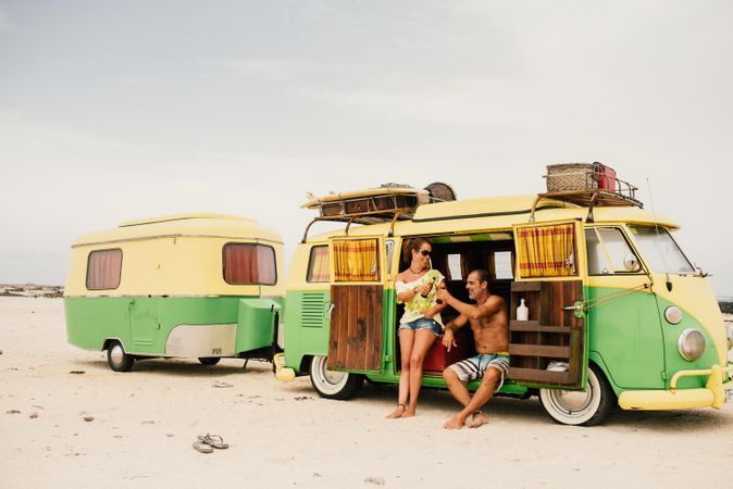 Friends in minibus with trailer on beach