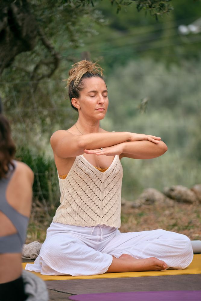 Woman doing yoga on mat during outdoor session with friend