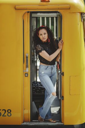 Cheerful hispanic woman standing on train in drivers cabin