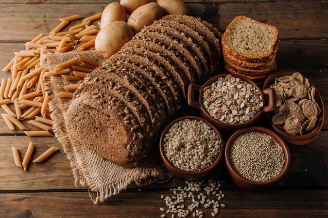 Wholegrain food pasta and freshly baked rye bread on table