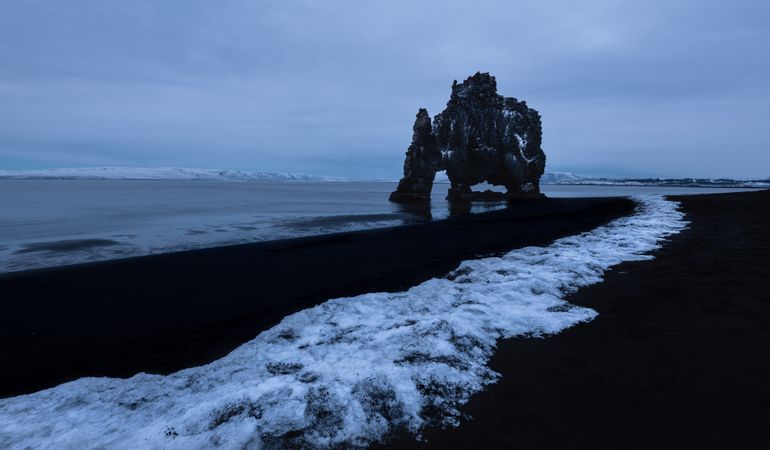 Rocky shoreline of sea in clouds in Iceland