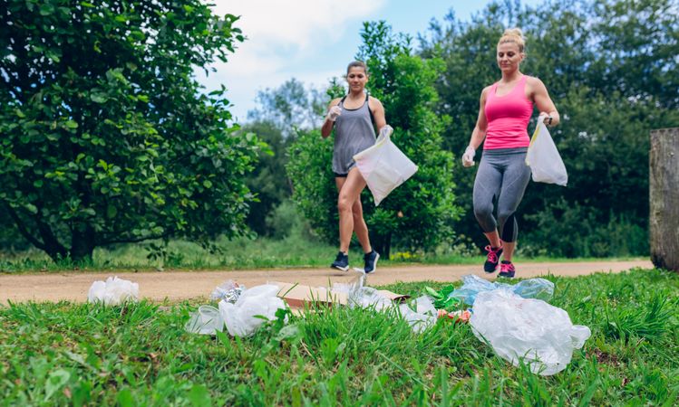 Waste pile and two woman doing plogging