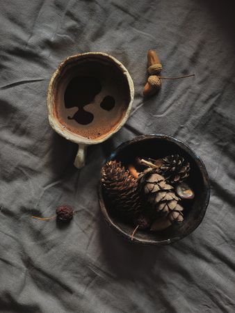 Top view of dark coffee in ceramic mug on bed