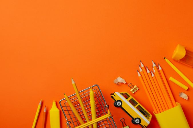 Frame of school supplies on orange background, space for text