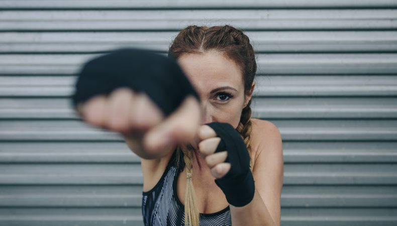 Sportswoman looking at camera and punching