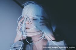 Portrait of woman with light hair holding blue led light thread closing her eyes 0Jxjr4