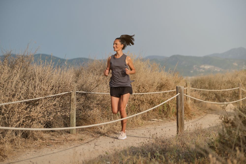 Cheerful woman running in countryside