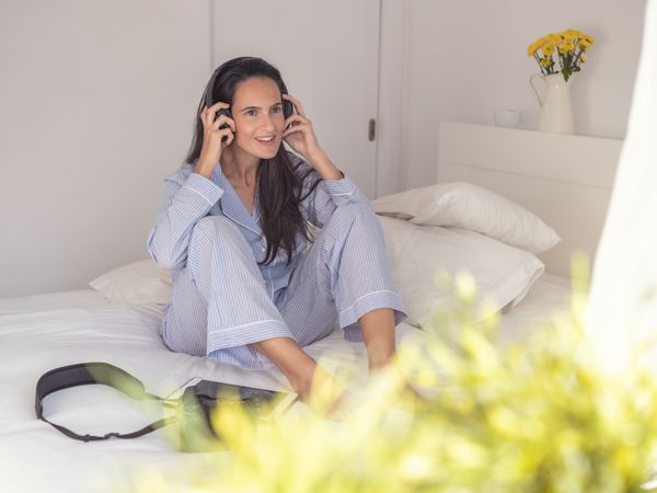 Woman listening to music on bed