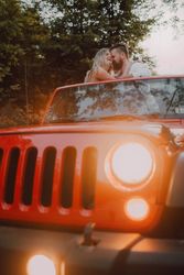 Loving couple sitting on car on road near forest