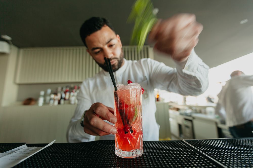 Cheerful Barman preparing alcoholic drinks in a bar.