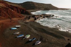 Boats on stony shore near sea