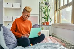 Smiling Black woman with a laptop in a bright modern home