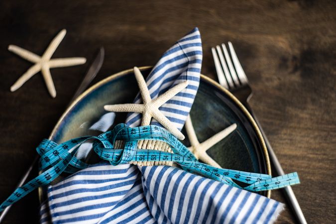 Coastal table setting with sea stars with blue striped napkin