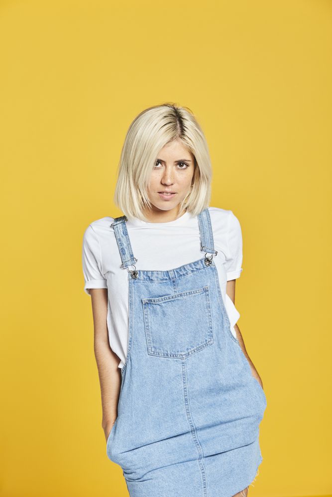 Trendy blonde female in denim sundress