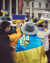 London, England, United Kingdom - March 5 2022: Woman in hat draped in Ukrainian flag