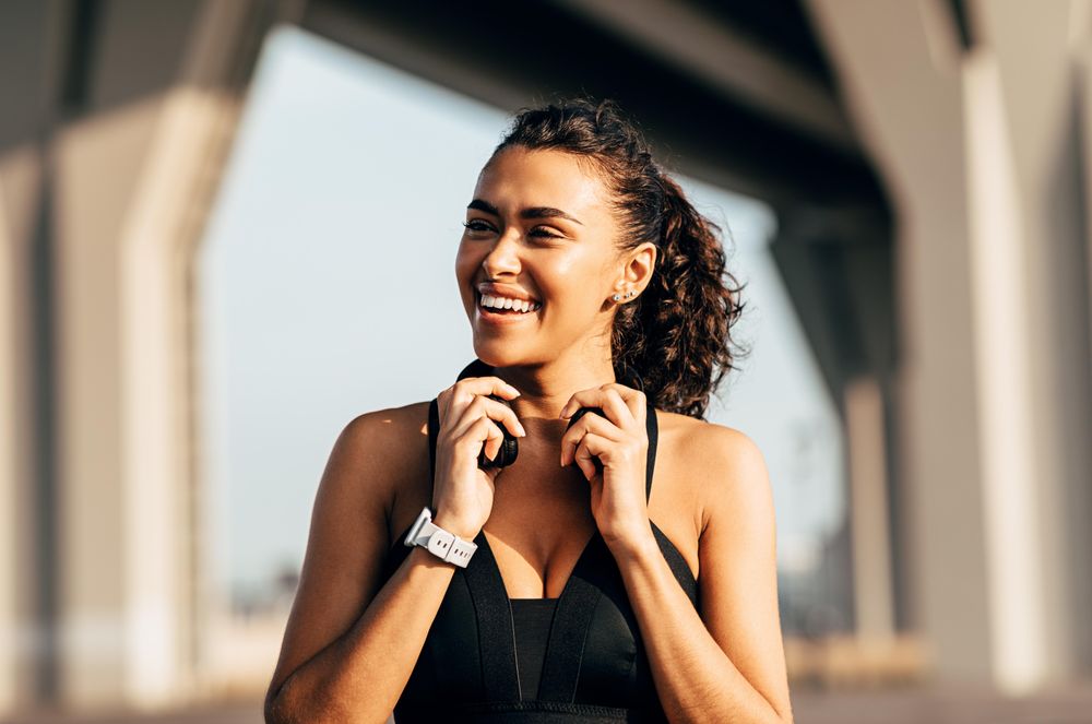 Woman holding headphones and smiling