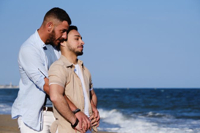 Gay couple hugging on seaside
