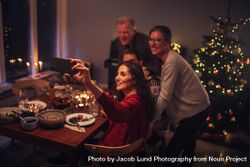 Adult family taking selfie with mobile phone at the dinner table on Christmas 0LAmE5
