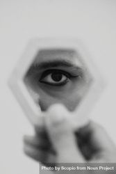 Grayscale photo of man looking at his eye in mirror 5k8mP4