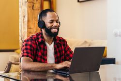 Black man teleworking with laptop from home